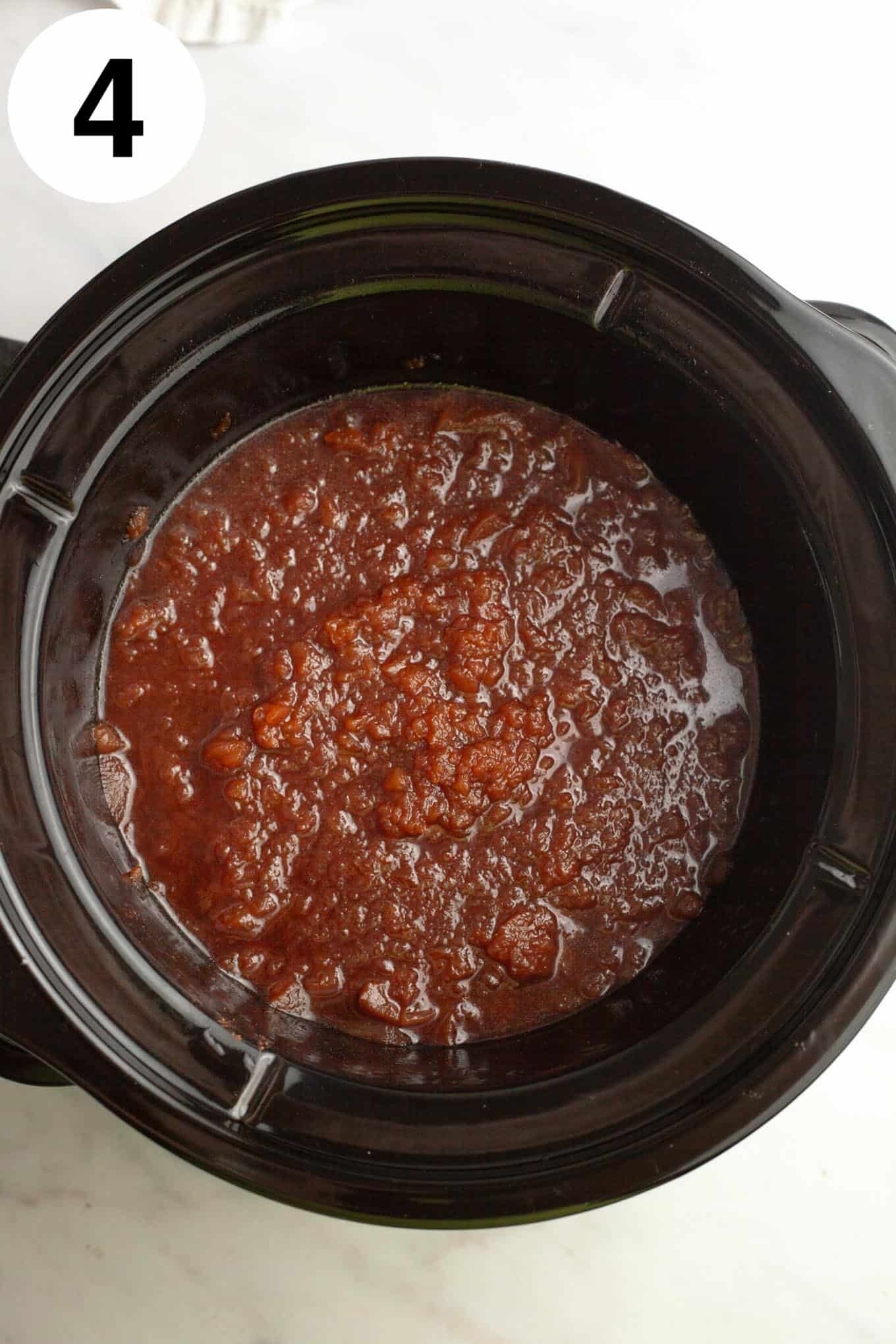 An overhead view of chunky apple butter in a Crockpot. 