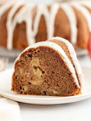 A slice of apple cake on a white plate.
