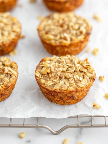 Baked banana oatmeal cups lined up on a cooling rack.