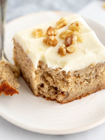A slice of banana cake with a piece taken out of it.