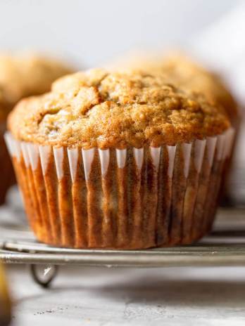 Banana muffins sitting on a round wire rack.