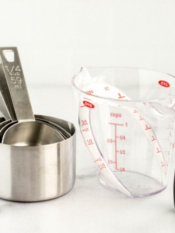 A stack of measuring cups and a liquid measuring cup side by side.
