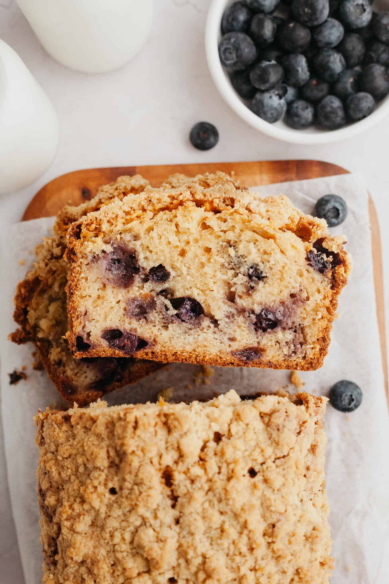 An overhead view of blueberry streusel bread slices stacked on their sides. 