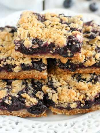 A stack of blueberry crumble bars on a white plate.