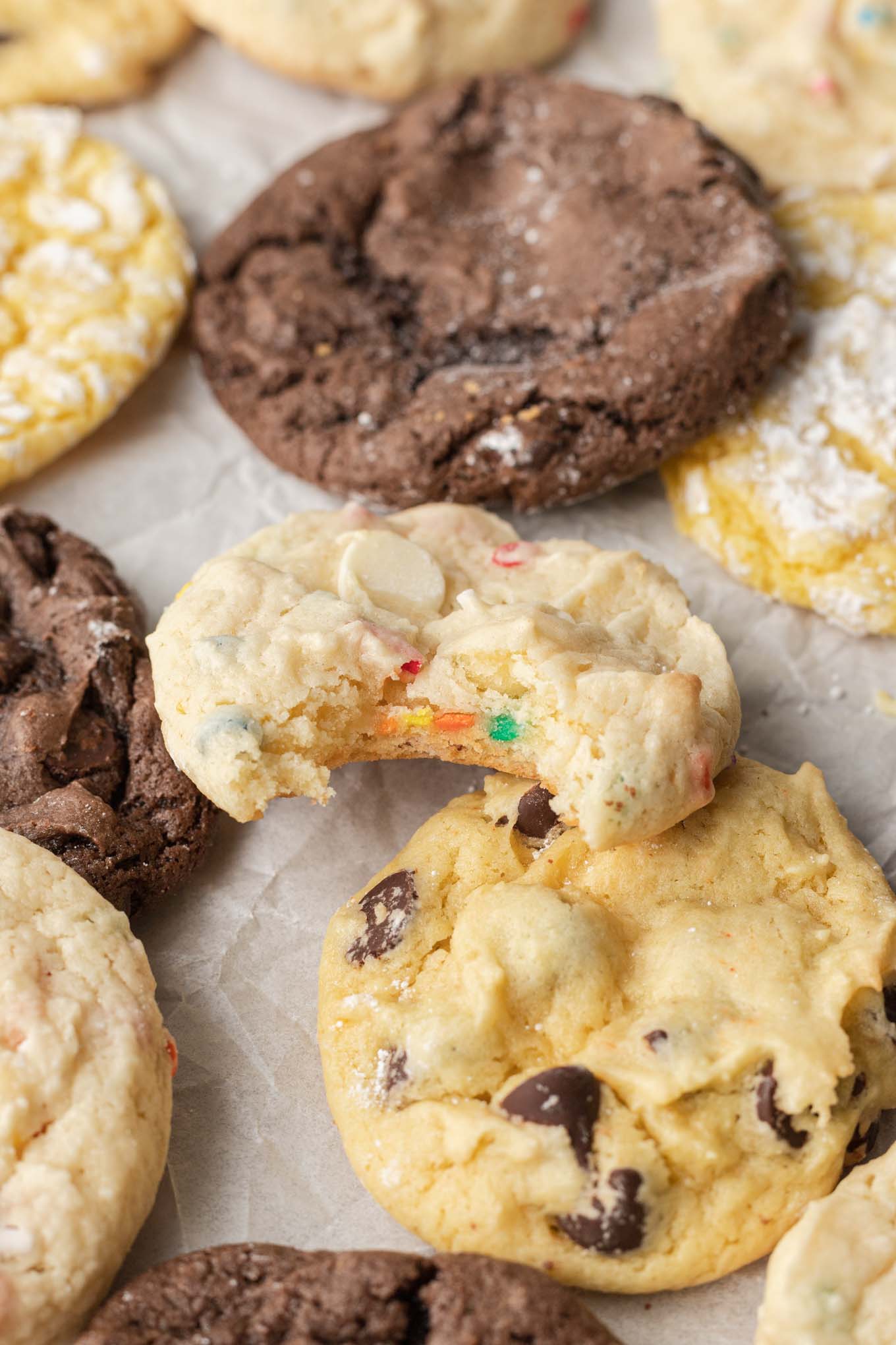 Different flavors of cookies on parchment paper.