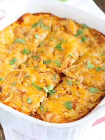 A baked chicken enchilada casserole in a white dish.
