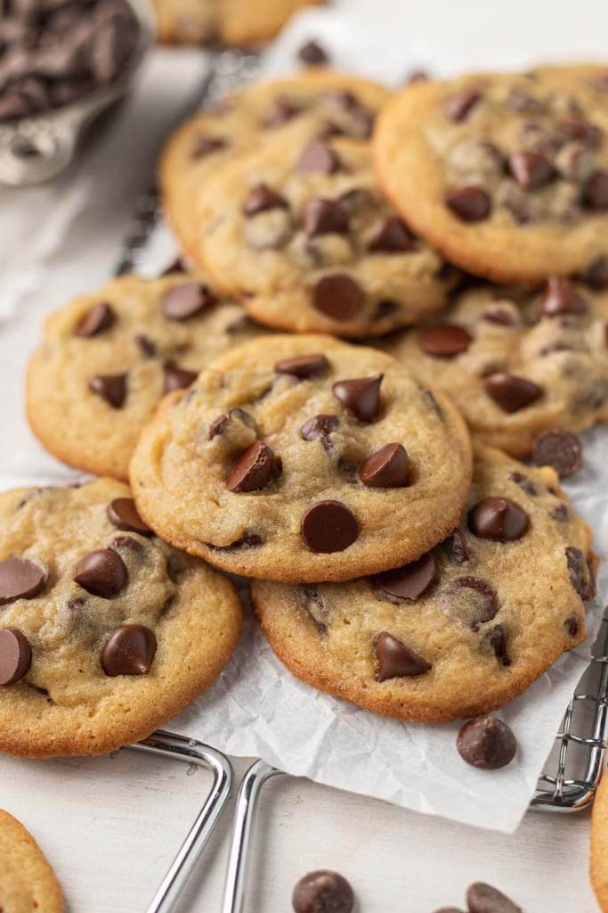 A pile of pudding cookies on a parchment-lined wire cooling rack. 