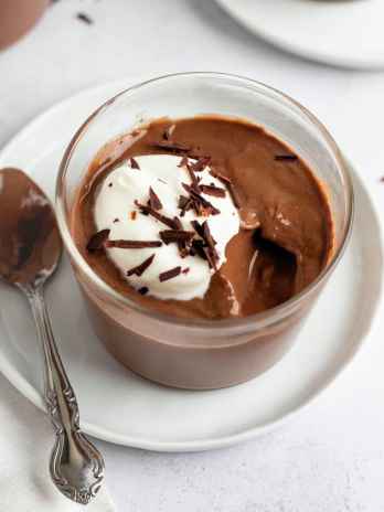A glass filled with chocolate pudding.