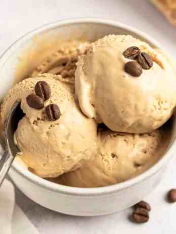 A bowl filled with three scoops of coffee ice cream.