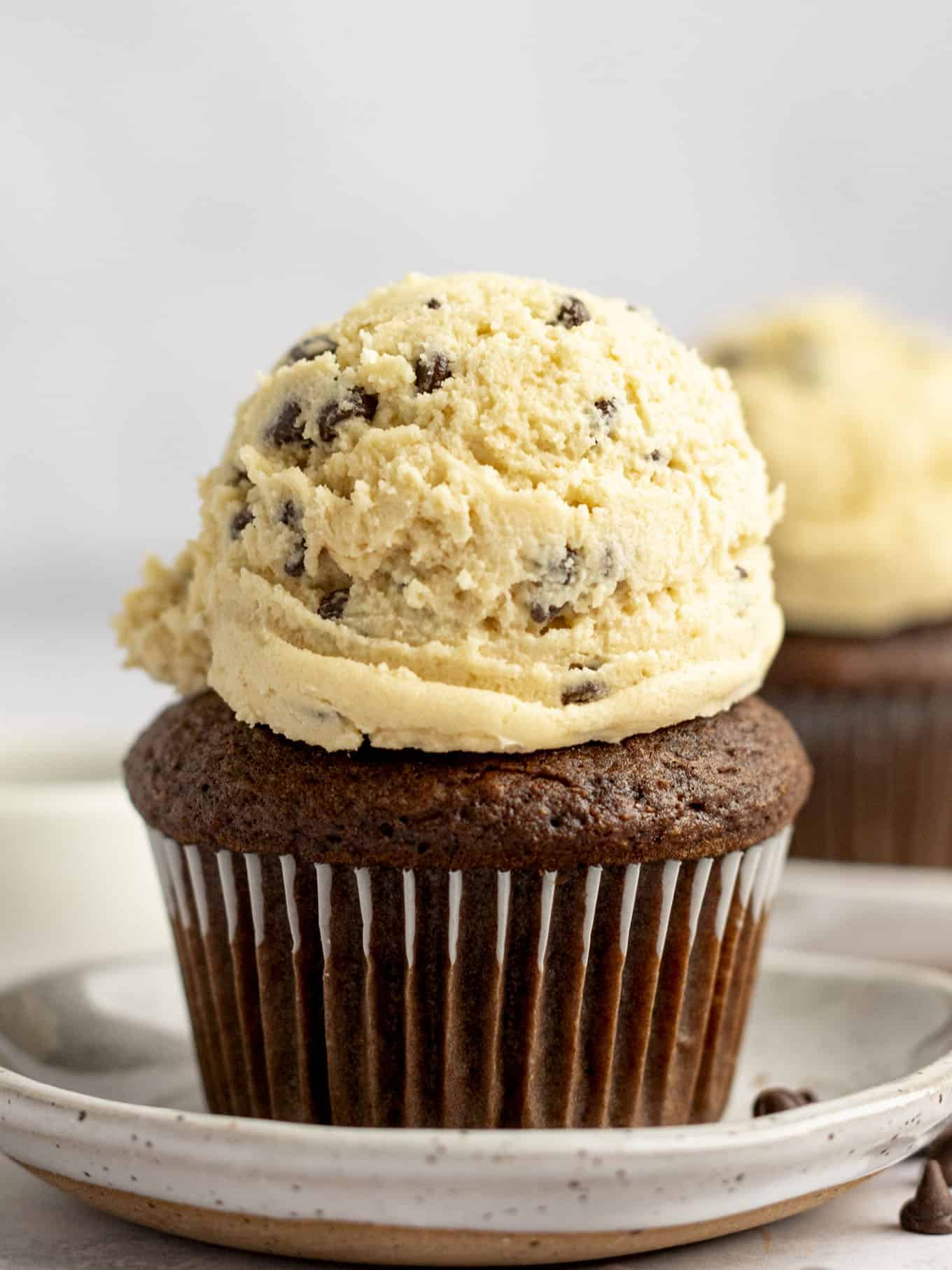 A chocolate cupcake topped with a scoop of cookie dough frosting. 