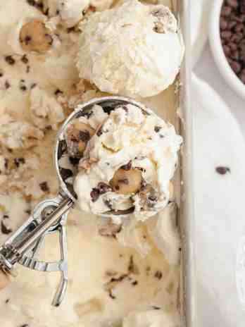 An overhead view of cookie dough ice cream with a scoop of ice cream resting on top.