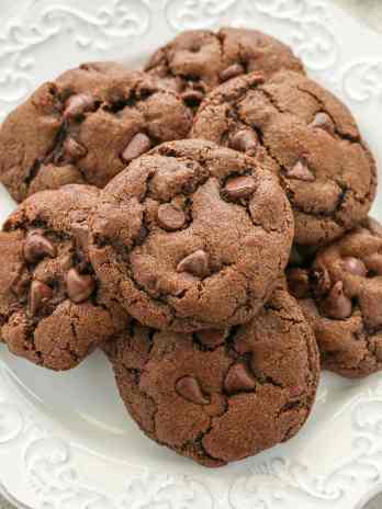 A white plate filled with double chocolate chip cookies.