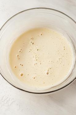 Frothy, cooked eggs in a glass mixing bowl.