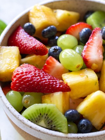 A white bowl filled with fresh fruit salad.