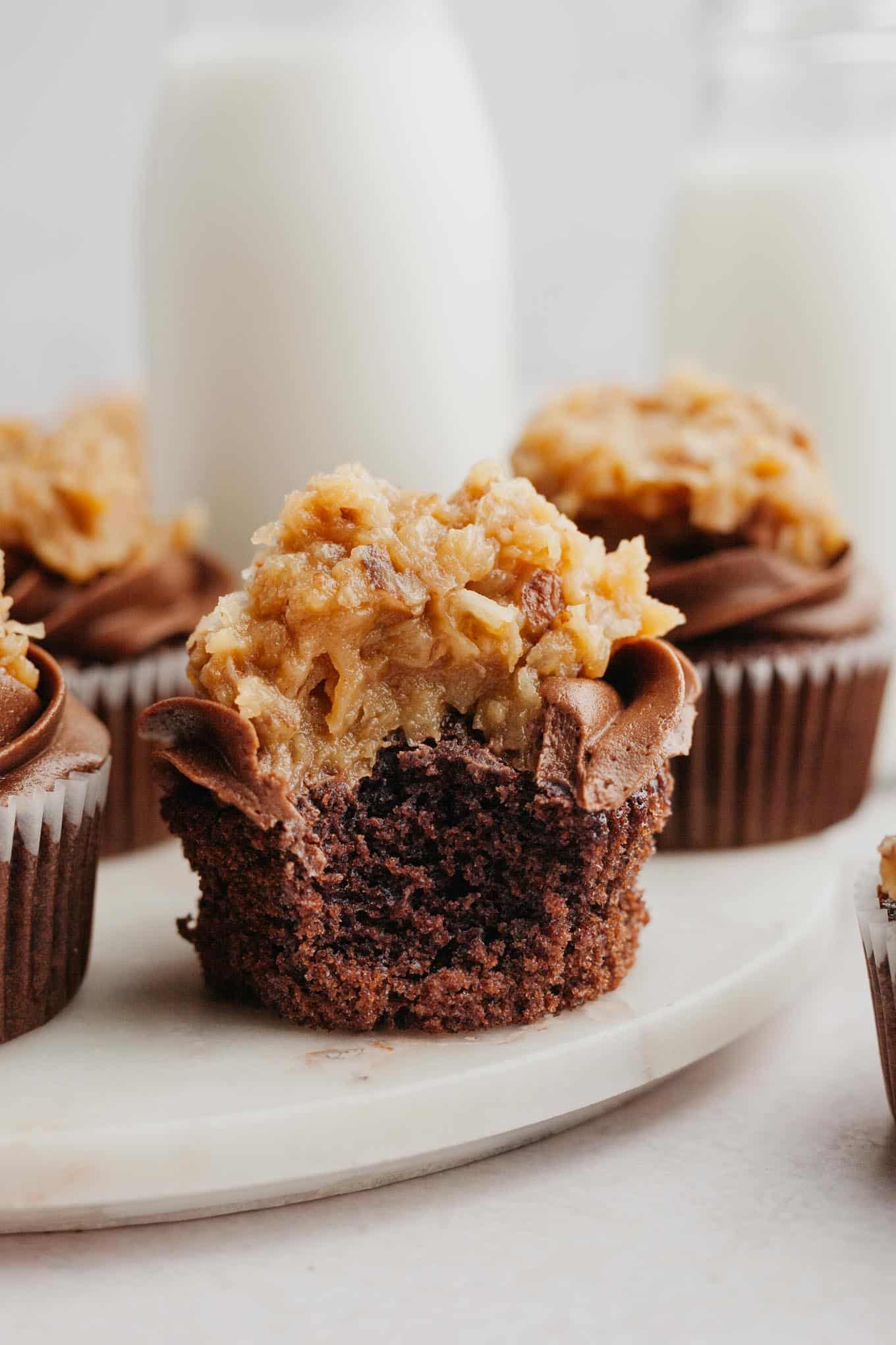 Frosted German chocolate cupcakes on a marble serving platter. 