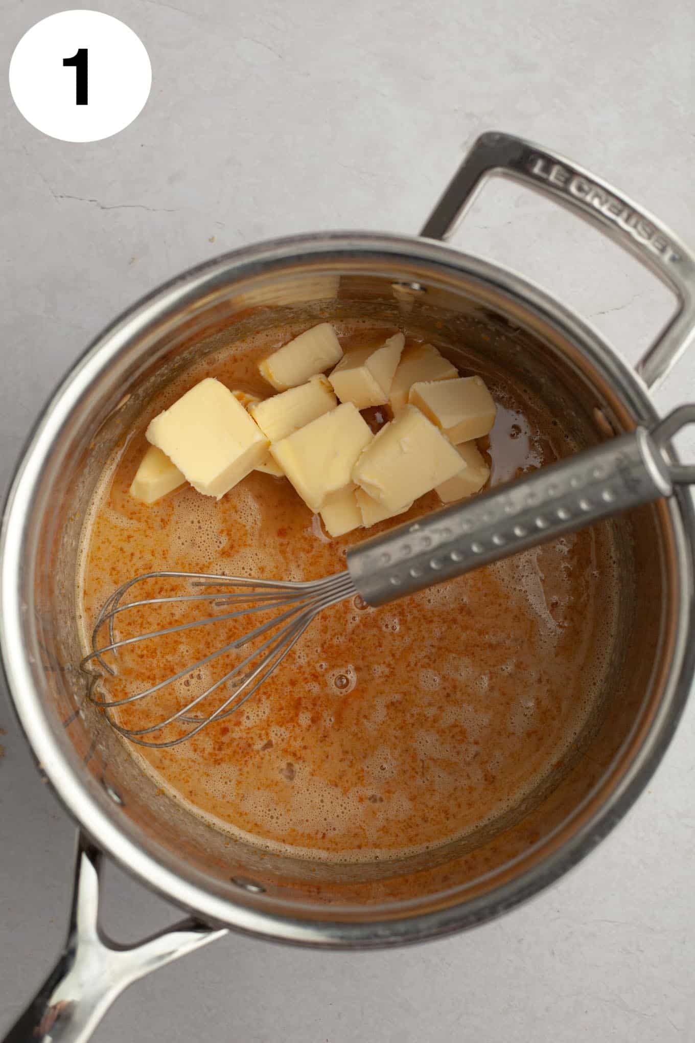 An overhead view of coconut pecan frosting ingredients in a saucepan. 
