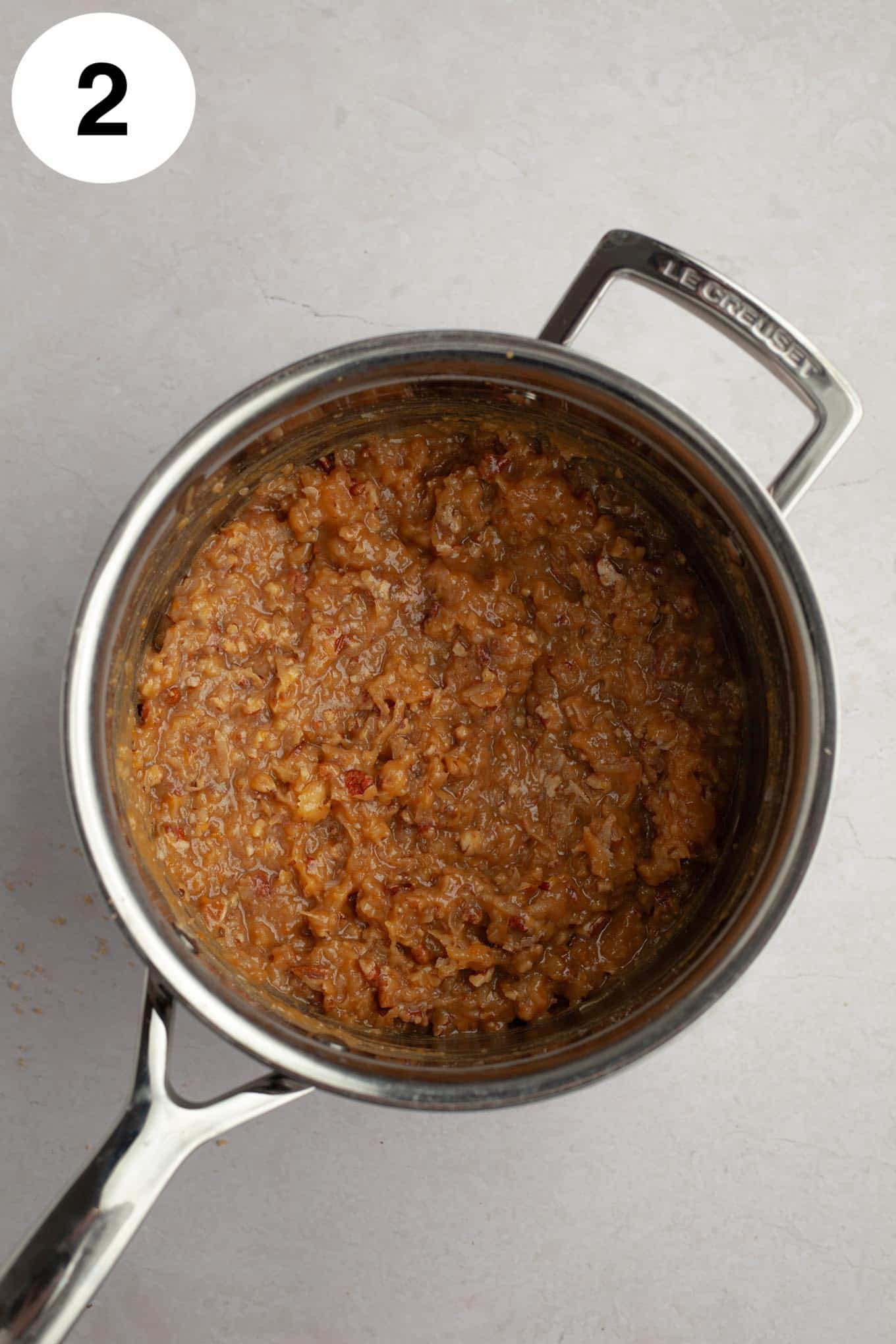 An overhead view of coconut pecan frosting in a saucepan. 