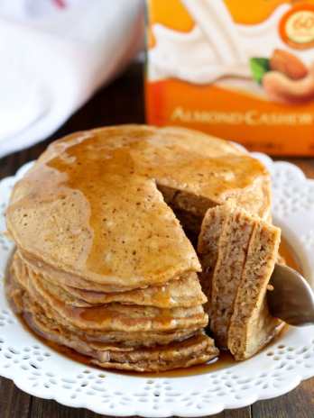 Stack of gingerbread pancakes on a white plate. A bite has been cut out.