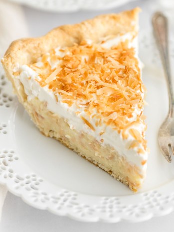 A close-up image of a slice of coconut cream pie on a plate.