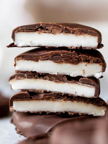 A stack of homemade peppermint patties cut in half to show the layers.