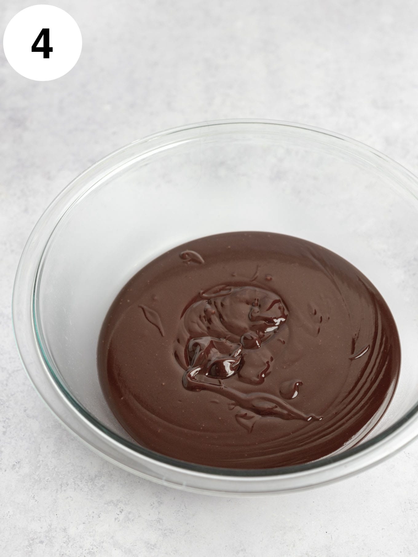 A glass bowl of hot fudge. 