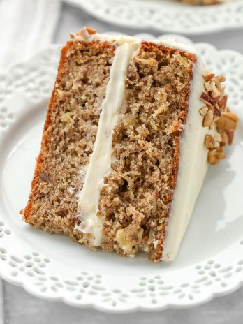 A slice of hummingbird cake on a decorative white plate.