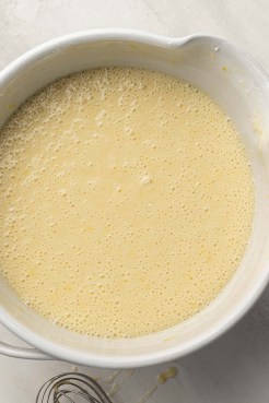 Lemon olive oil cake batter in a white ceramic mixing bowl.