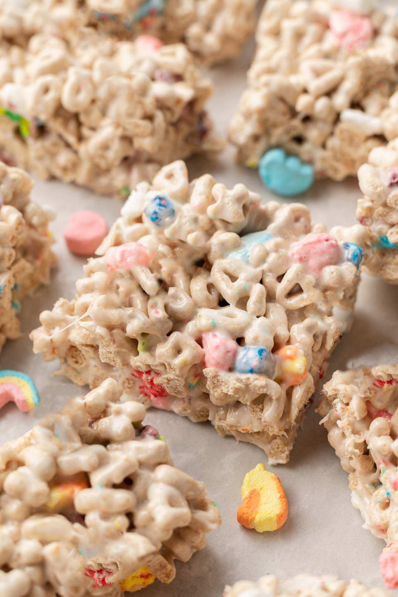 A close-up view of sliced Lucky Charms bars on parchment paper.