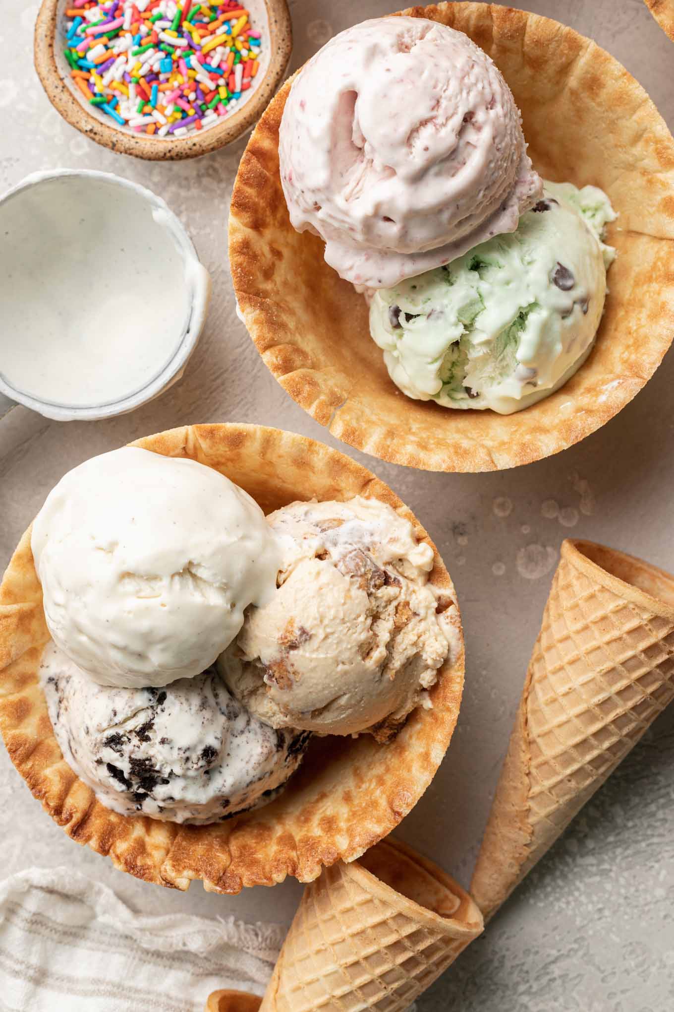 An overhead view of two waffle cone bowls filled with scoops of homemade no churn ice cream.