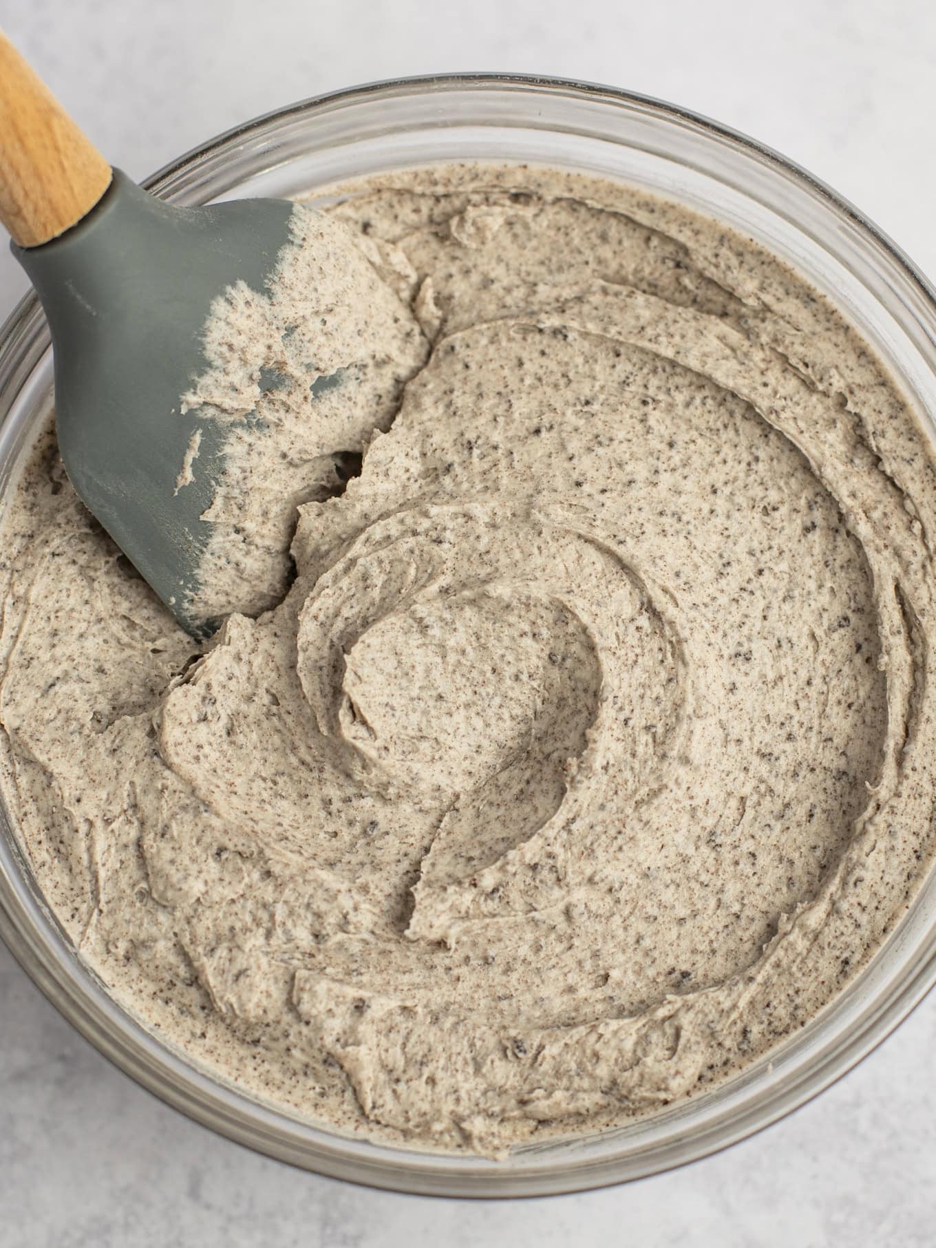 A glass mixing bowl filled with Oreo frosting.
