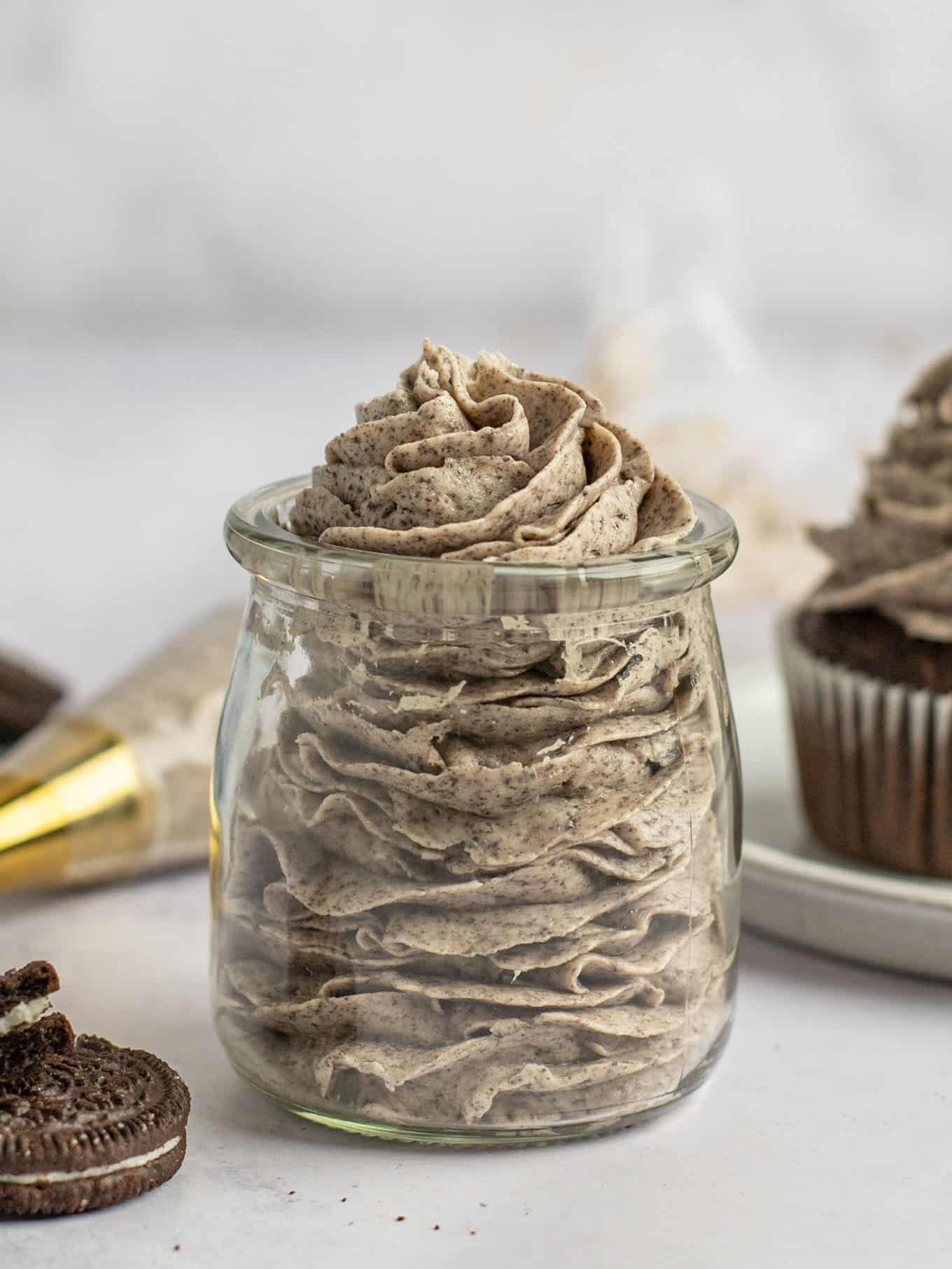 A side view of piped Oreo buttercream in a glass jar. 