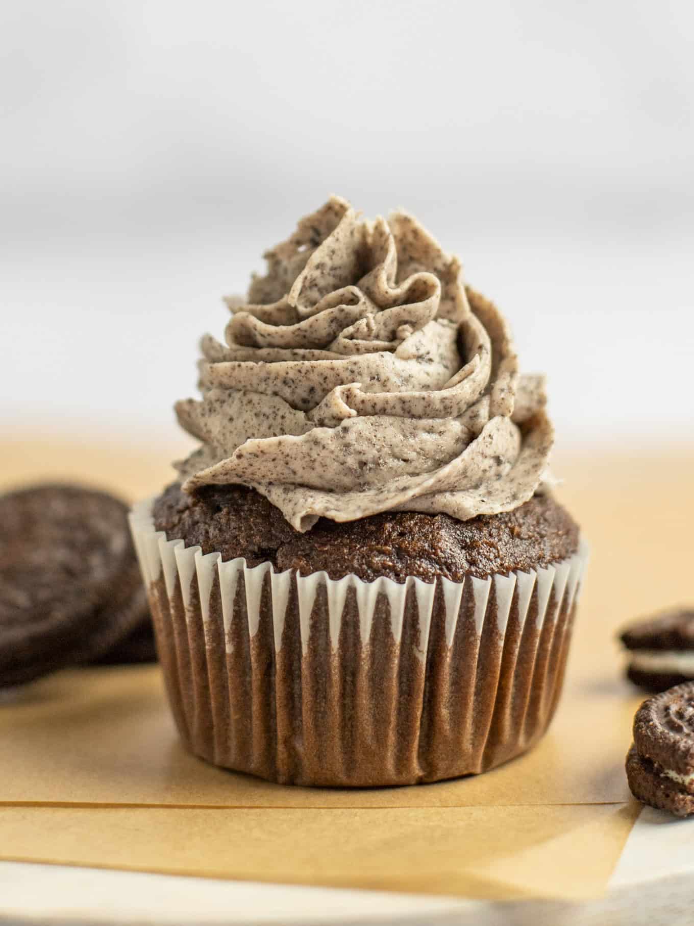 A side view of a chocolate cupcake piped with Oreo frosting. 