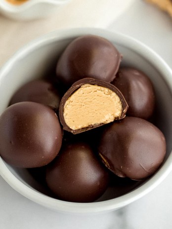 A small white bowl filled with peanut butter balls.