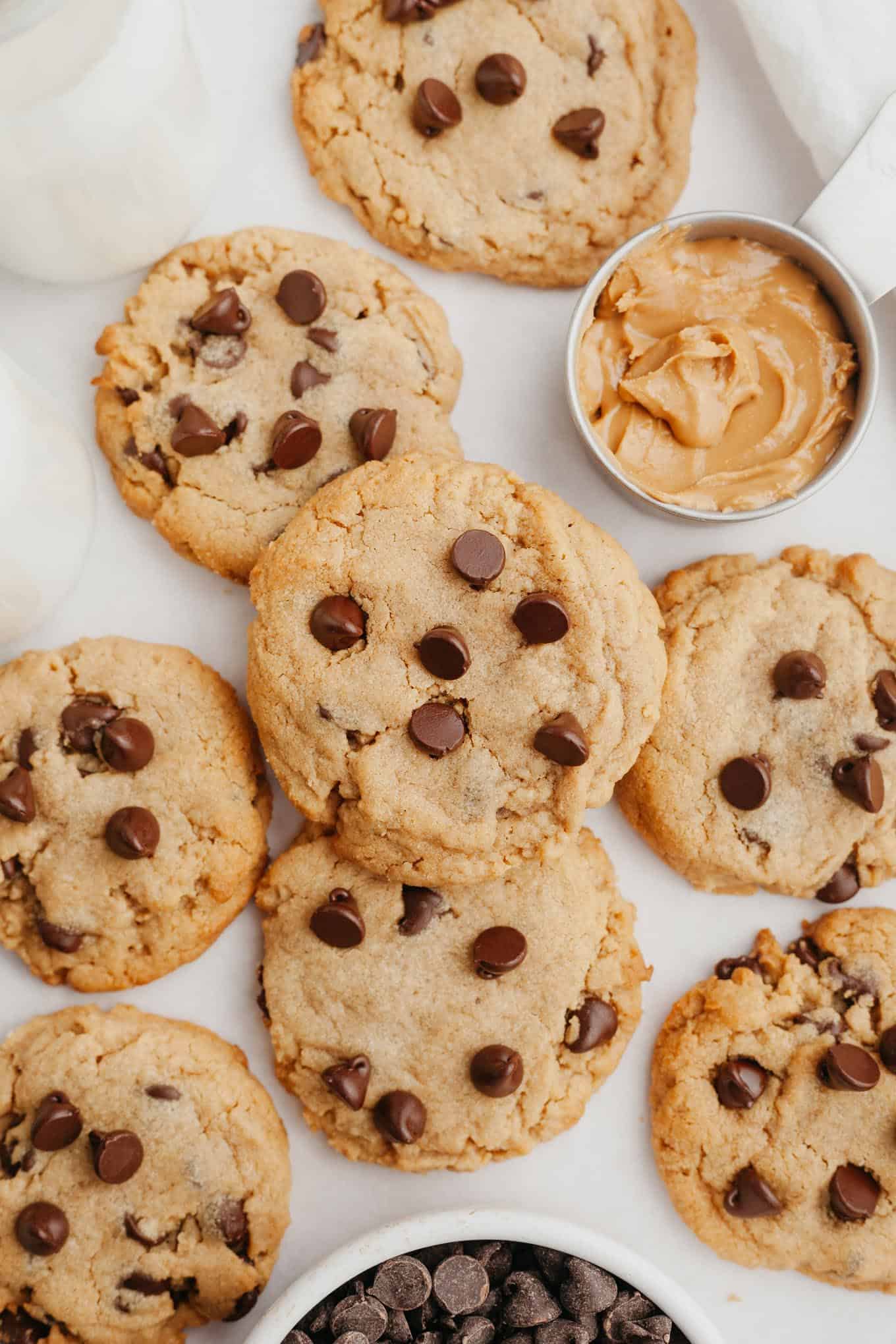 An overhead view of a pile of peanut butter cookies with chocolate chips. 