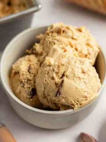 A bowl filled with three scoops of peanut butter ice cream.