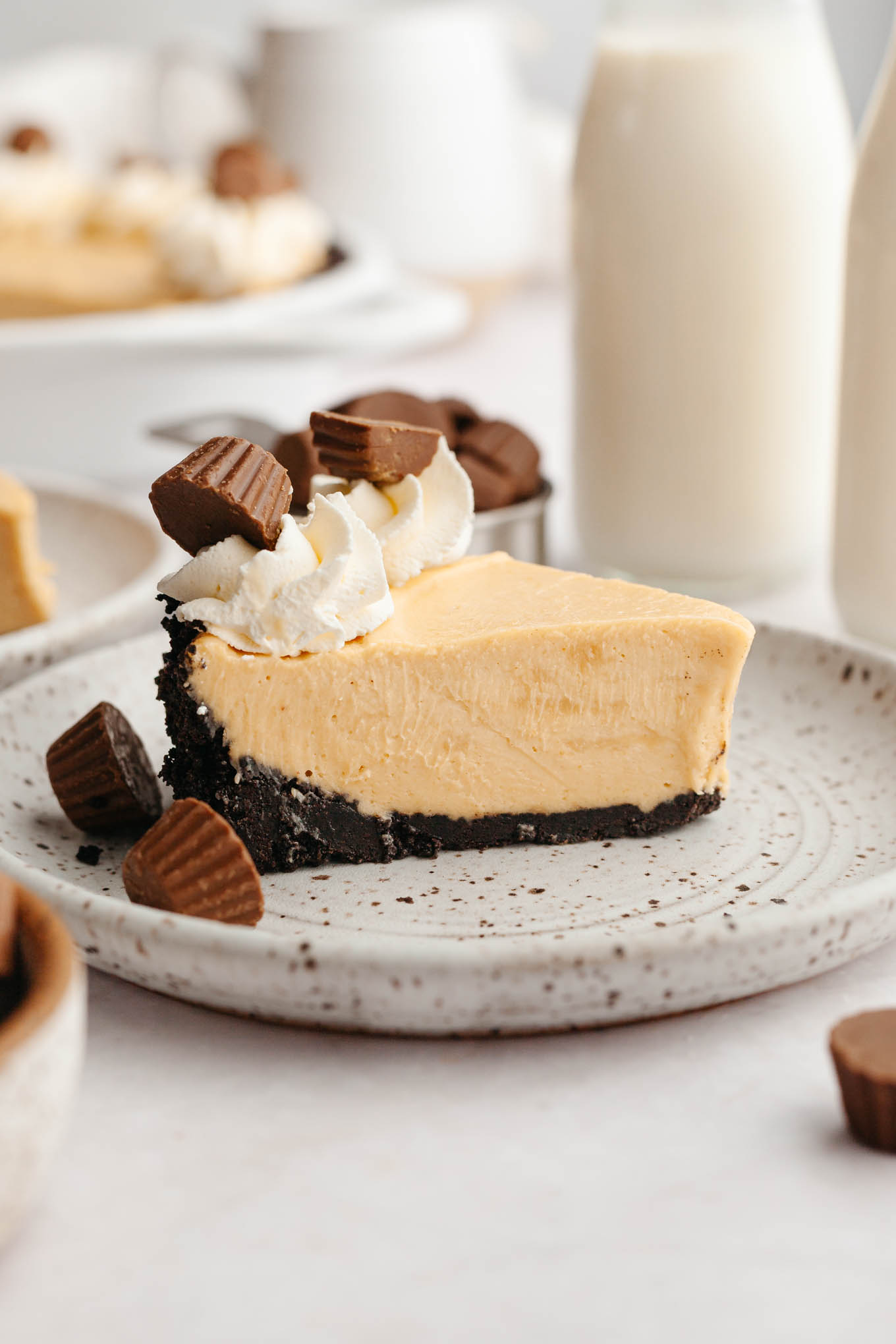 A slice of peanut butter pie garnished with whipped cream and peanut butter cups.