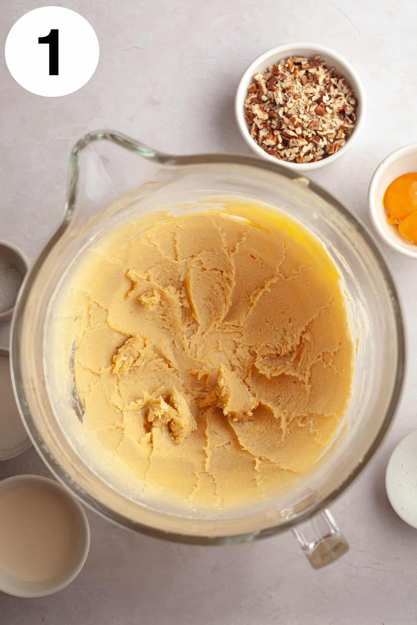 An overhead view of creamed butter and brown sugar in a glass mixing bowl. 