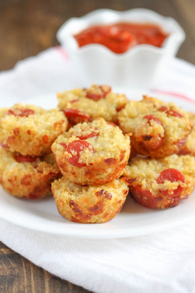 Several mini quinoa pizzas on a plate.