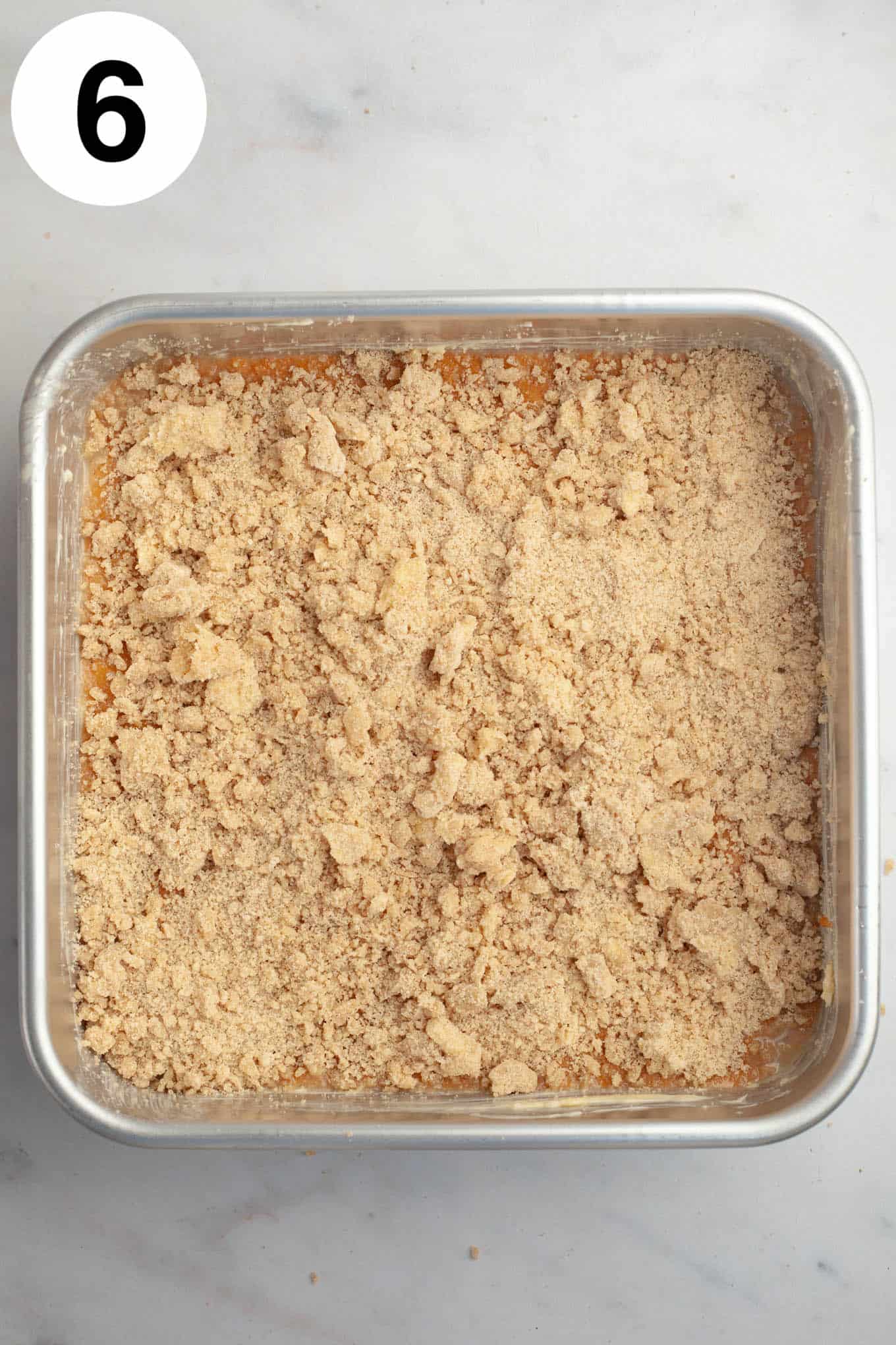 An overhead view of an unbaked pumpkin streusel coffee cake. 