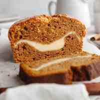 A loaf of pumpkin cream cheese bread that's been sliced.
