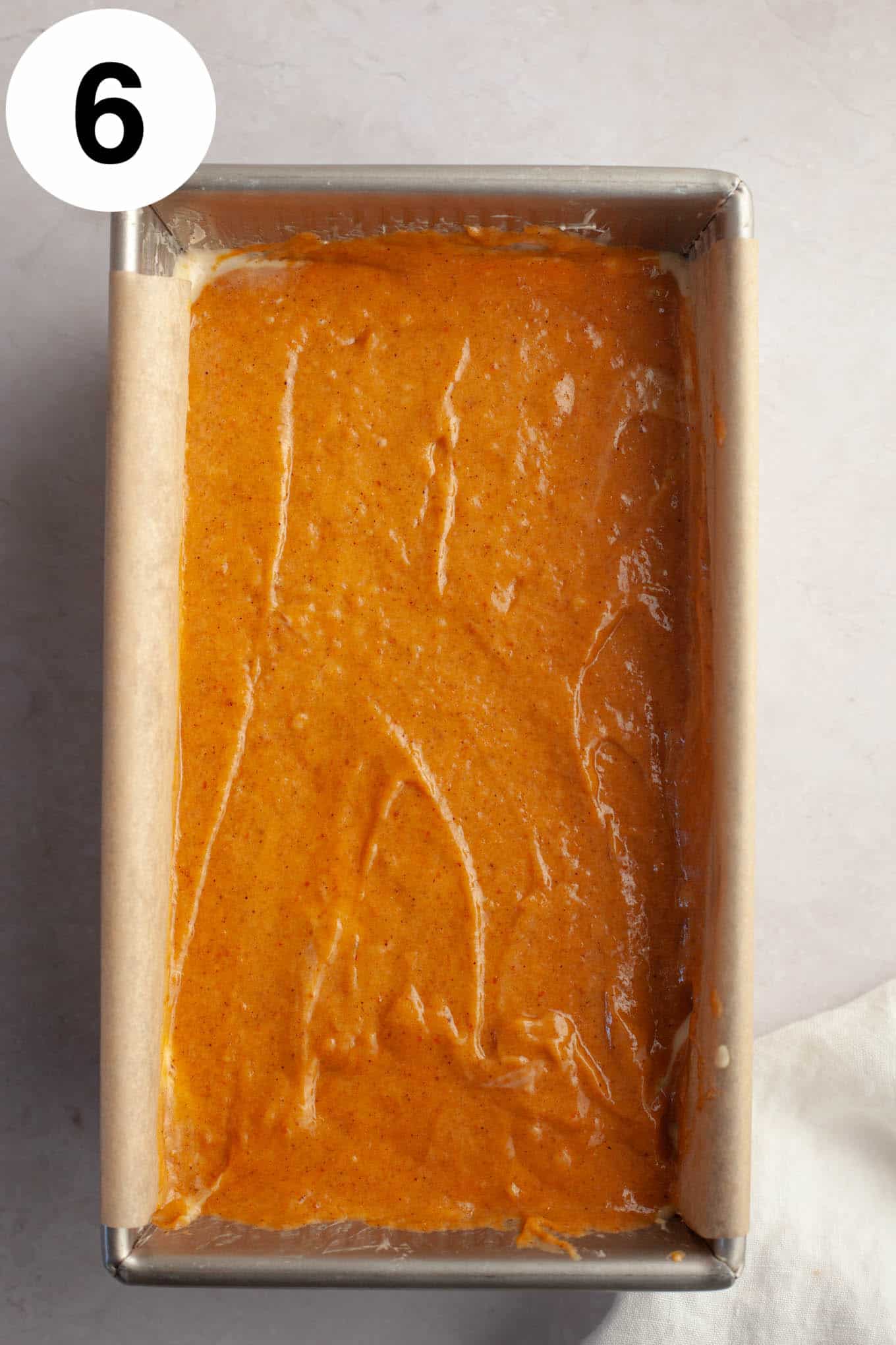 An overhead view of an unbaked loaf of pumpkin bread in a loaf pan. 