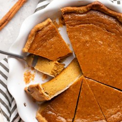 A pumpkin pie sliced into pieces.