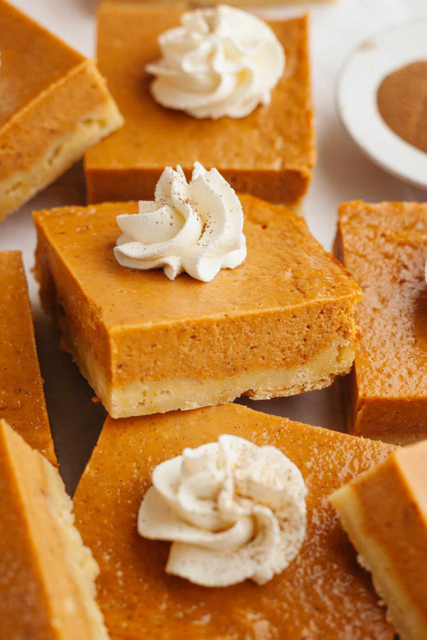 Pumpkin pie bars arranged so they're partially stacked atop one another.
