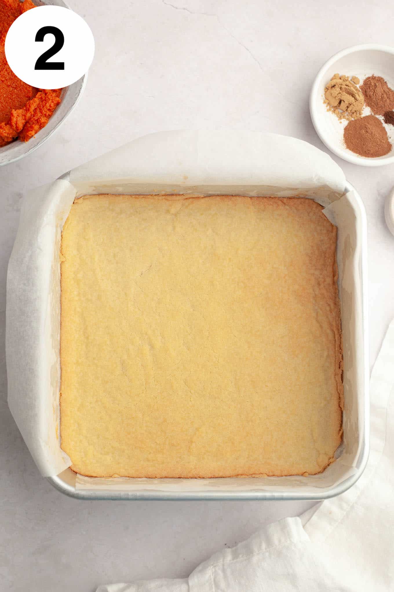 An overhead view of a baked shortbread crust in a 9-inch pan. 