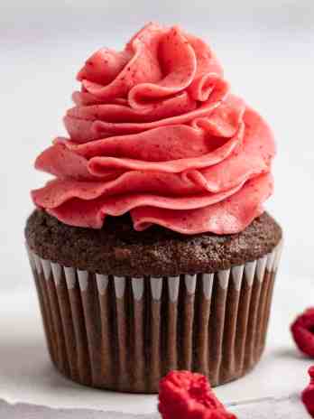 A chocolate cupcake topped with raspberry frosting.