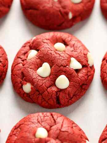 Red velvet cookies lined up on a piece of parchment paper.
