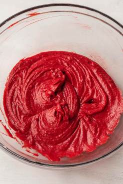 An overhead view of the wet ingredients for red velvet cookies in a glass mixing bowl.