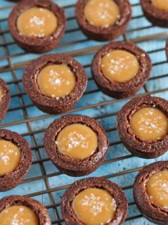 Salted caramel brownie bites sitting on top of a wire cooling rack.