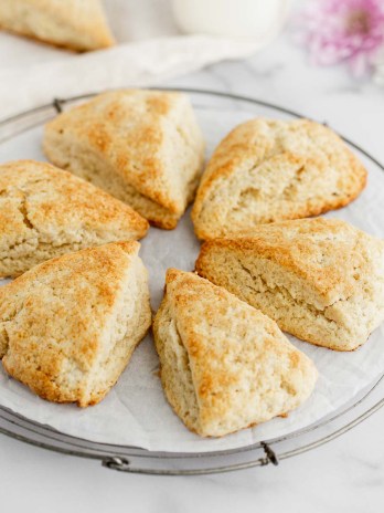 A batch of baked scones on a round wire rack.