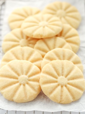 A group of shortbread cookies piled onto an antique safety grater.